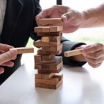 Two hands playing blocks wood game, gambling placing wooden block. Concept Risk of management and strategy plan, growth business success process and team work.