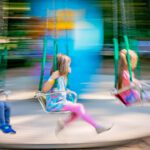 Unidentifiable children riding on a carousel in an amusement park, image with intentional movement blur